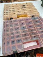Top view of two plastic organization bins with multiple compartments and clear lids. Bins measure approximately 12 x 16 x 2.5 inches.
