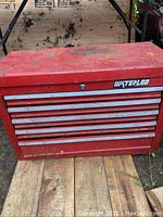Front view of the red Waterloo toolbox showing five drawers and top tray with visible rust and wear.