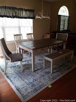 Full dining set from front, table with three drawers, two captain chairs at ends, two side chairs and bench visible