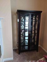 Full front view of tall dark wood curio cabinet with glass doors
