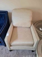 Front view of beige upholstered armchair showing overall condition