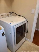 Dryer front left quarter view showing overall exterior and attached power cord