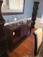 Front view of dark brown sideboard with glass doors and drawers
