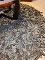 Close-up image of round suede rug showing layered suede strips in various earthtones.