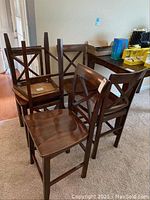 Set of five wooden chairs grouped together showing their overall design and condition.