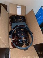 Box with 15 assorted pairs of sunglasses in various styles and colors, including aviator and wrap-around.