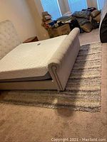 Rug under bed showing the size and striped pattern gray and cream tones