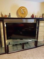 Front view of curved TV mounted on stand within entertainment unit