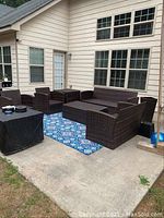 Full view of the entire patio set arranged on concrete patio against house exterior