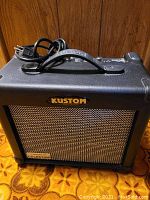 Black Kustom amplifier with a metal mesh front grille and Kustom brand logo.