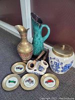 Overview of all items in the lot showing Delft jar, pitchers, pipes, pipe holder, and coasters