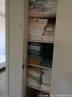 View of linen closet with folded towels, sheets, and bedding organized on five shelves