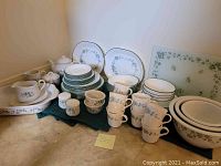 Full lot on countertop showing plates, cups, saucers, bowls, serve items