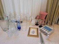 Wide view of assortment showing glass and ceramic vases, candles, tea light candles, holders, and framed flower art