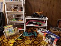 Photo of toys including plastic shelves, vehicles, books, and soldiers on a patterned carpet.