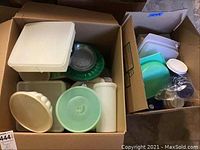 Two boxes filled with assorted Tupperware and plastic containers and lids of various shapes and sizes.