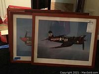 Four framed vintage aircraft prints stacked, showing partial views of the planes and frames with scratches