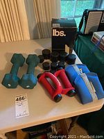 Photo showing the entire set of weights and accessories on a table under natural light, including the box for weights.