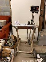 Full view of metal cart with mounted JCPenney electric outboard motor, showing wheels and control handle.