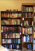 Image showing two wooden bookshelves filled with books, demonstrating the size and style of the shelves.