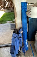 Blue Quick Shade canopy in carrying bag with collapsible metal frame visible