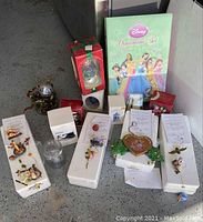 Photo showing multiple Winnie The Pooh collectible ornaments displayed on white styrofoam bases alongside boxes including a Disney ornament set and cookie cutters.