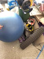 Photo showing blue exercise ball, black foam roller, purple dumbbells, resistance bands, yoga mat, and abdominal wheel roller clustered together