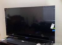 Front view of Sony 54-inch flatscreen TV with visible Sony logo and soundbar below the screen, indicates overall condition and components included.
