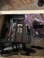 Five kitchen drawers with assorted kitchen utensils including knives, forks, spoons, cutters, and miscellaneous tools.