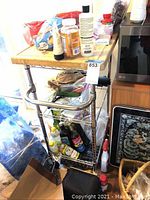 Full view of the rolling kitchen cart showing wood top, metal frame, wire shelves, and caster wheels.