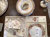 Overall view showing multiple sets including Limoges fish plates and boxed dessert sets by Tominga Japan and Sadek