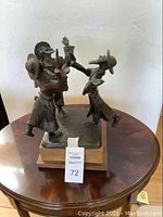 Full view of metal on wood dancing rabbis sculpture
