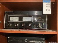 Front view showing dual analog VU meters, input source selectors, tone and gain knobs