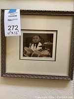 Full view of framed art print featuring a drummer in black and white, with ornate silver frame and matting.