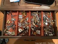 Open drawer showing various men's cufflinks, including silver-tone and turquoise Native American styles