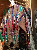 Front view of hand knitted brown Pierre Cardin cardigan with geometric colorful knit pattern.