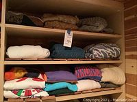 Shelves with assorted folded sweaters in various colors and patterns.