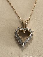 Heart-shaped diamond pendant on 18" gold chain displayed against light background