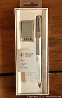 Front view of the Microsoft Surface Pen in original packaging showing pen and battery charger tool