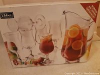 Box showing set with one glass pitcher and six sangria glasses, with colorful 'Sangria' lettering and brand Libbey visible.