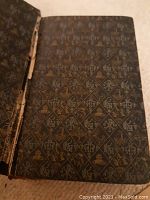 Photo of the inside front cover showing decorative endpaper with Christian symbols.