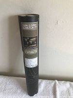 Rolled-up scratch map in black packaging with labeled text and world map image on packaging