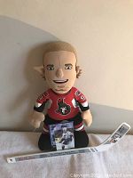 Plush figurine of hockey player Brett Hull with a miniature Tim Hortons branded hockey stick laid in front