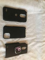 Top view of three black smartphone covers arranged on a white surface, showing cutouts for cameras and buttons