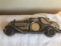 Front view of metal Rolls Royce car shaped wall thermometer on white cloth background