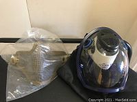 Both masks and carrying bag displayed on a surface against a wall.