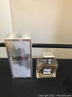 Two cologne bottles: one boxed La Bella Classic No.1 Eau De Parfum and other clear square bottle with silver cap