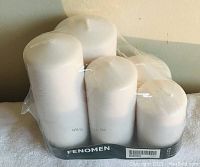 Set of five new white pillar candles in plastic packaging labeled Fenomen