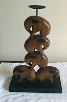 Front view of the 4 tier wooden elephant candle holder showing the four stacked elephants and the circular candle platform on top.