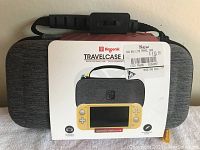 Front view of the Biogenik Travel Case packaged, showing it is new with a price tag of $19.99, and a picture of a yellow Nintendo Switch Lite on the packaging.